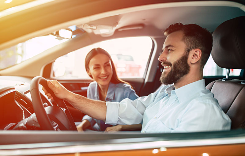 Refinance-your-car-loan-and-smile-at-the-savings-like-this-couple-driving-into-the-sunset.